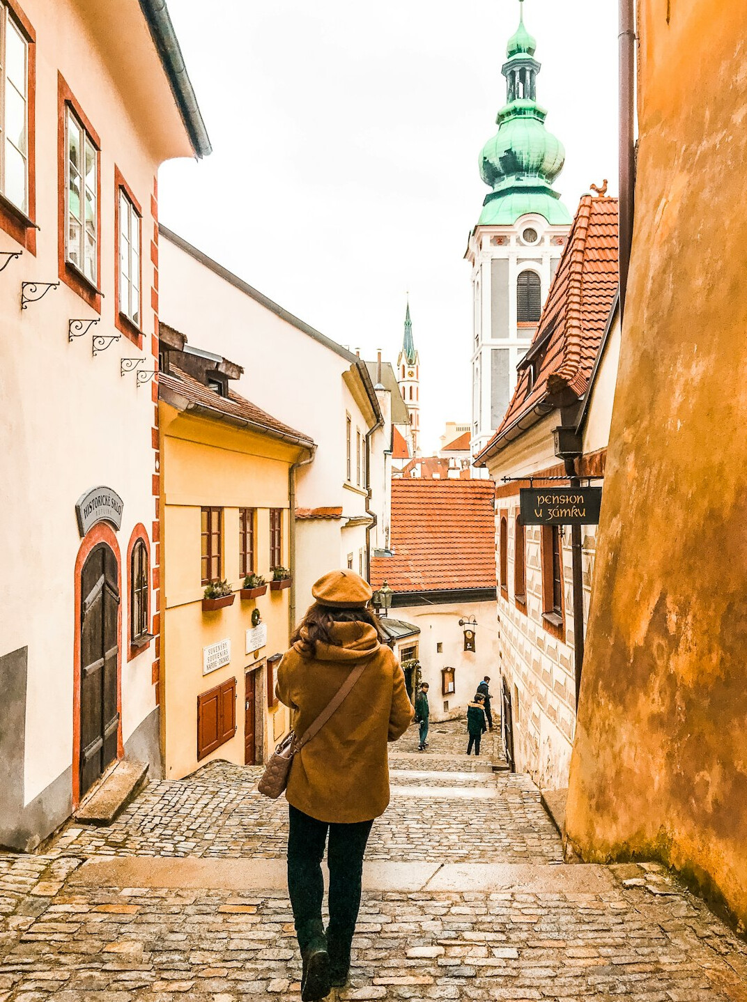 Photographer walking through a small Polish town street with a camera