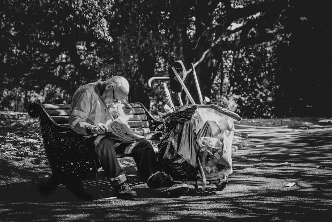 Photographer interviewing an elderly man on a park bench